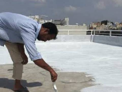 Worker applying the base coat of terrace waterproofing