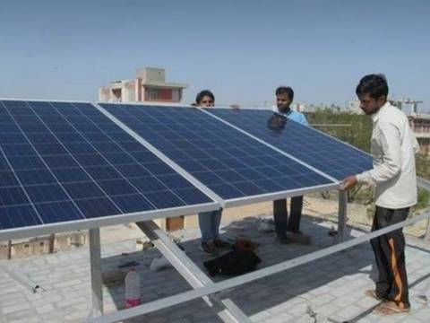 Team placing rooftop solar panels on the structure